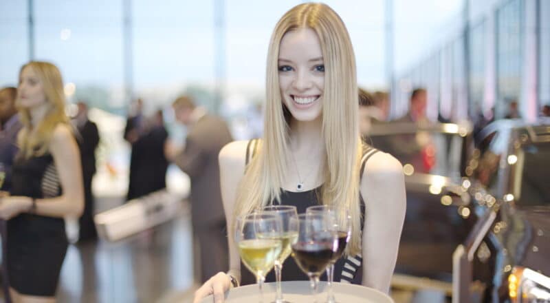 a person holding a tray of wine