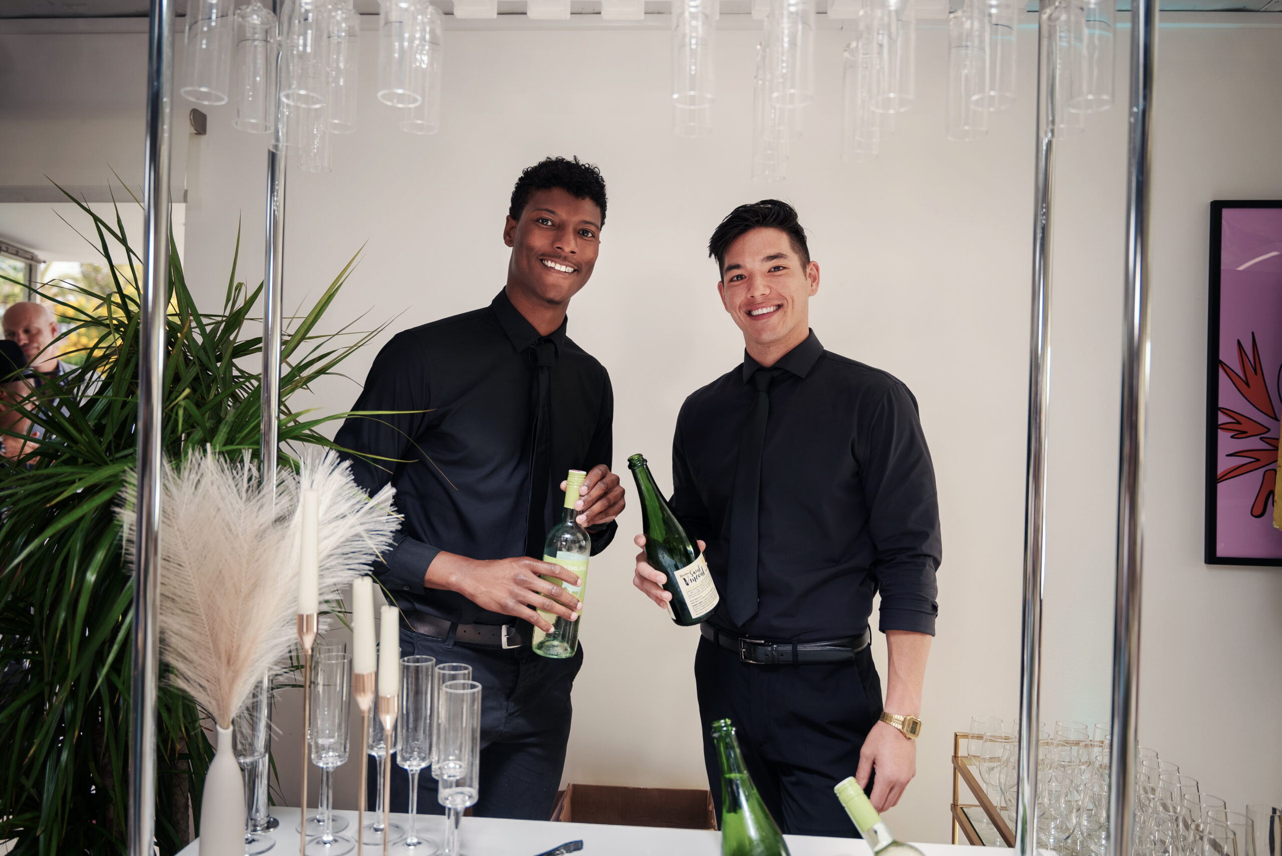 two men holding bottles of wine